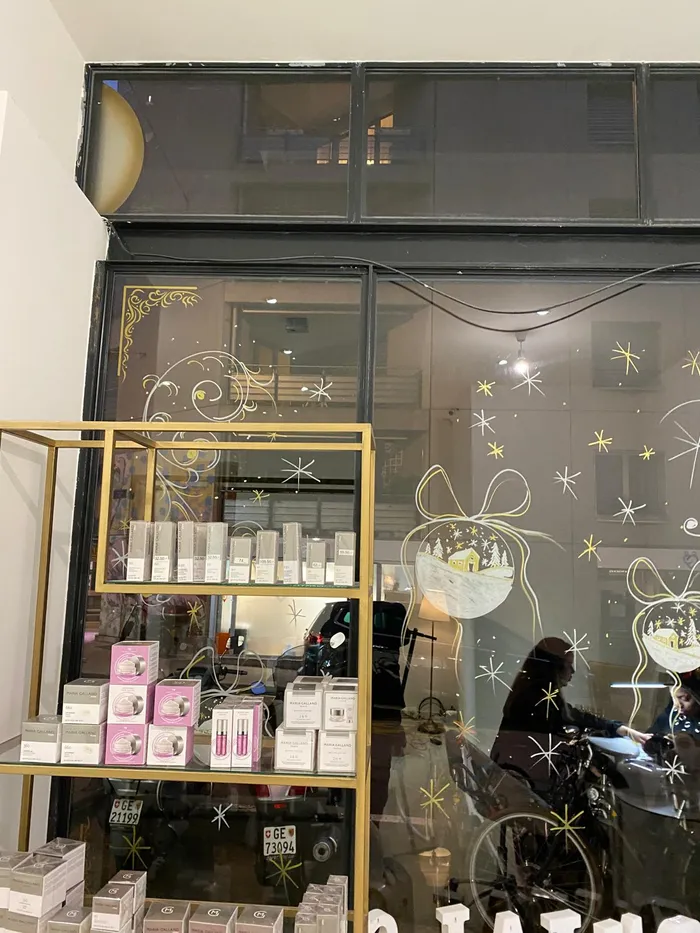 Golden Christmas decor painted on a salon window