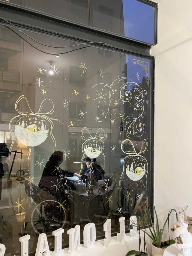 Vitrine d’institut décorée de boules et rubans de Noël peints