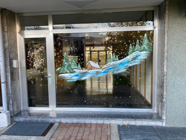 Vitrine de commerce avec paysage enneigé et message de fêtes